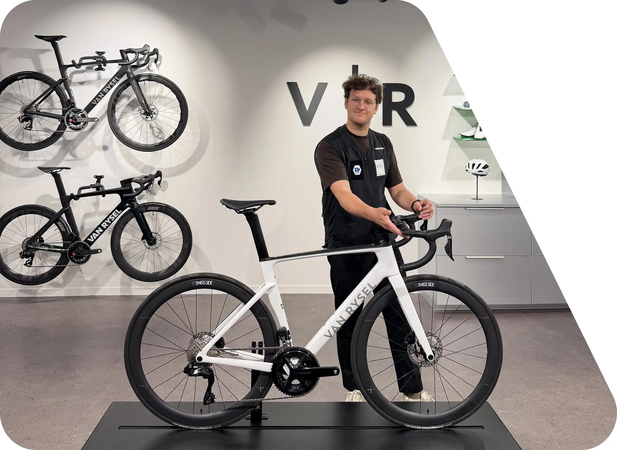Homme tenant un vélo route entre ses mains van rysel