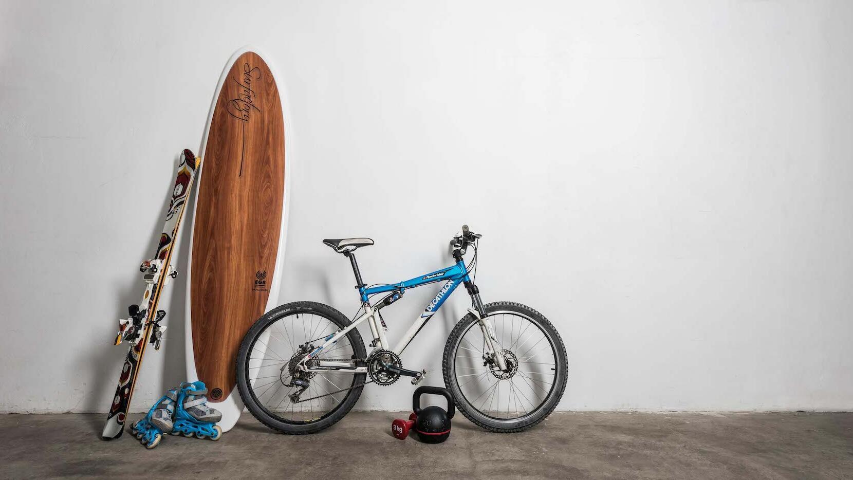 Picture of a bike, a surfing board and skies