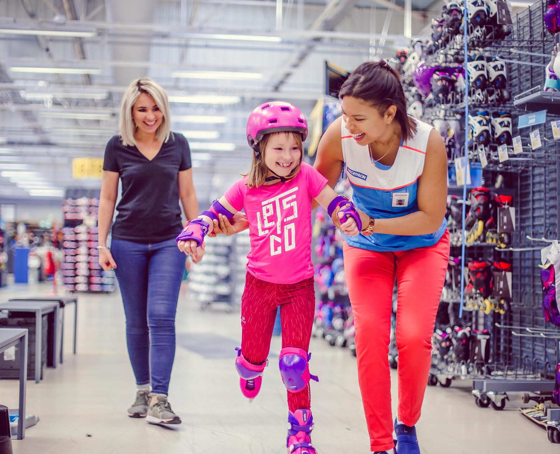 Criança experimenta patins em loja, com ajuda de colaboradora.