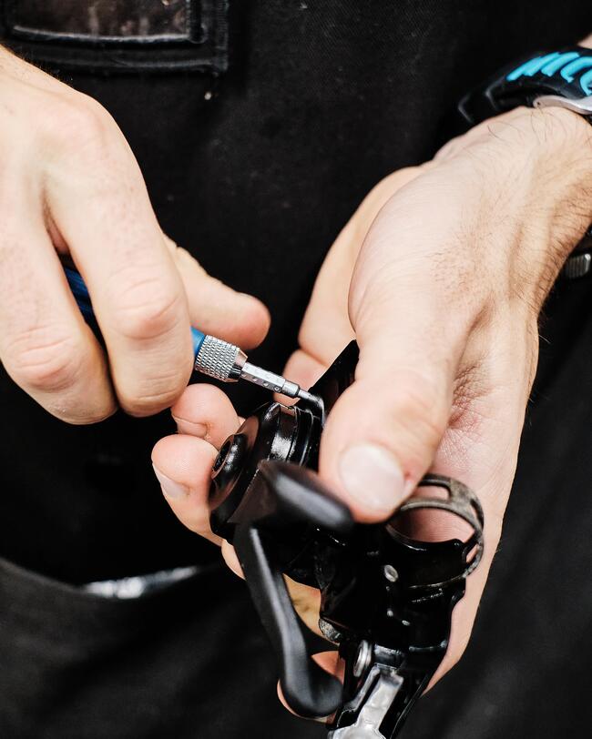 Hände reparieren Gerät mit Schraubendreher, schwarze und blaue Akzente, grobe Textur.