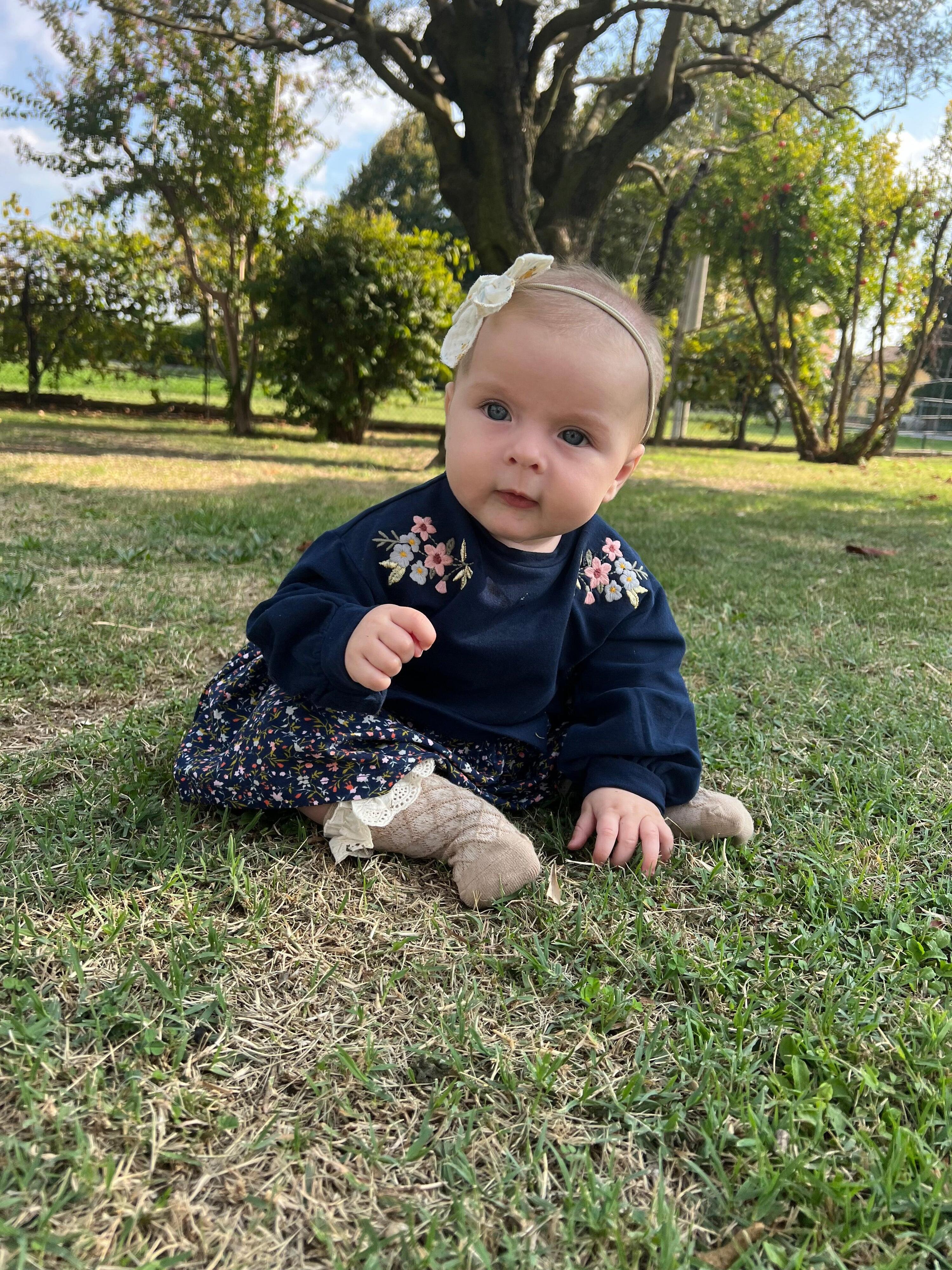 Vestido infantil azul marinho com estampa floral. 3/5