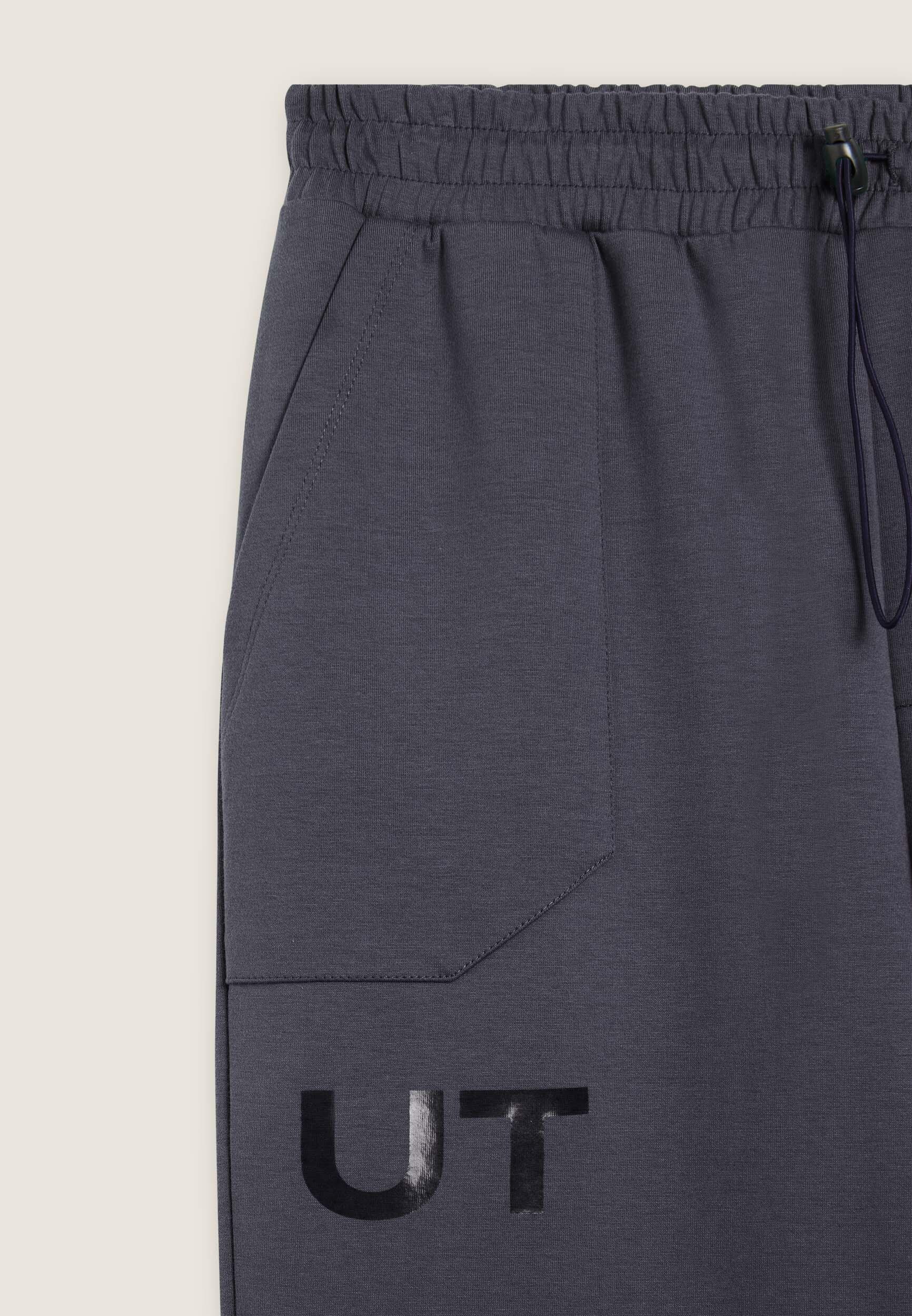 Pantalón slim fit en tejido interlock con estampado UT y costuras 3/4