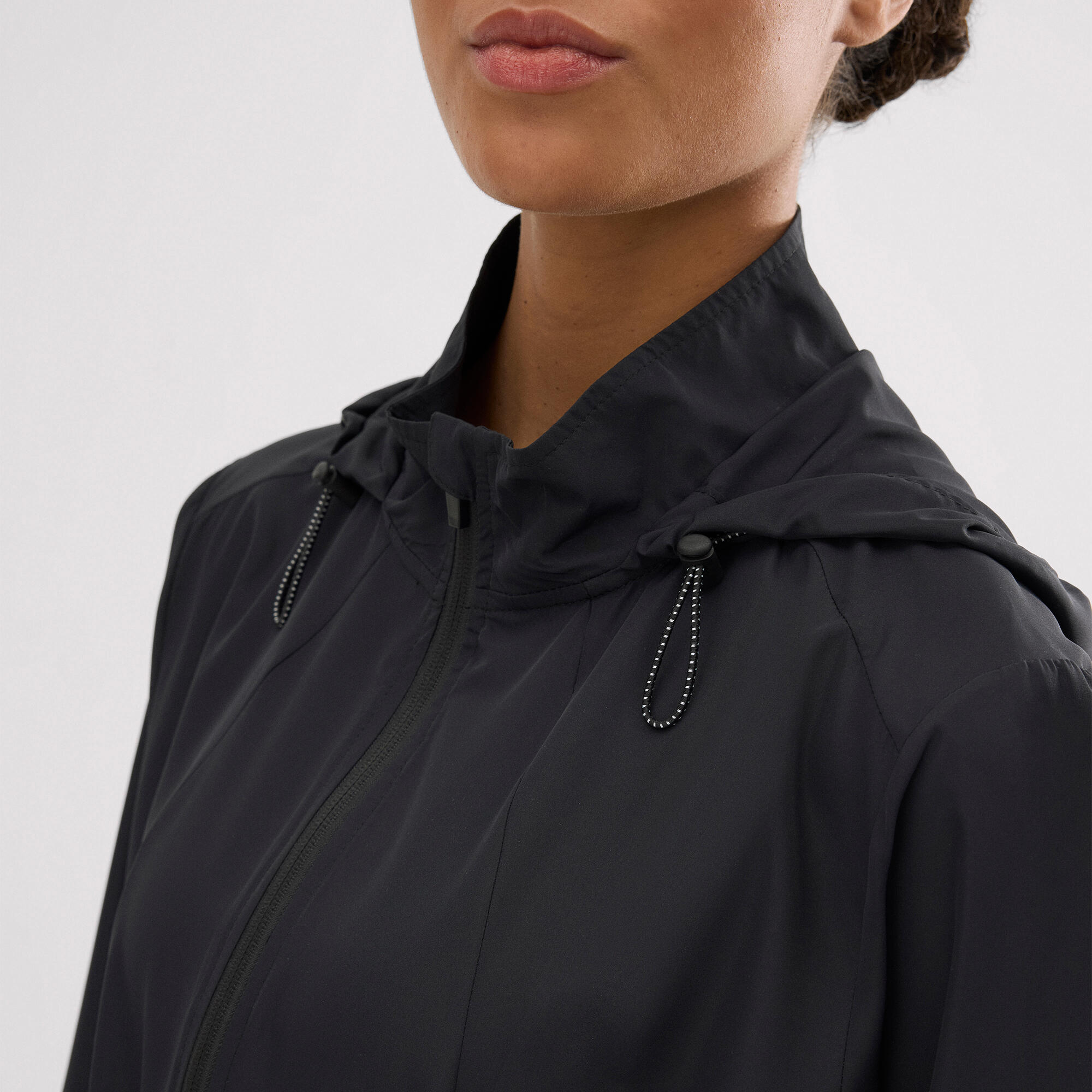 Chaqueta deportiva cortavientos con capucha y bolsillos negra 3/4