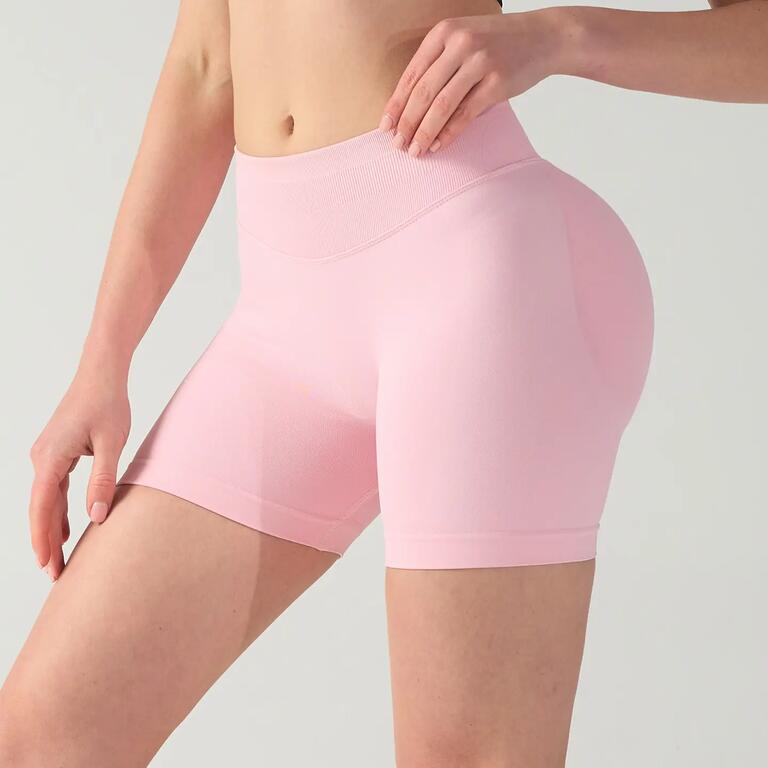 Pink women's yoga shorts with a wide high-rise waistband and fitted mid-thigh design