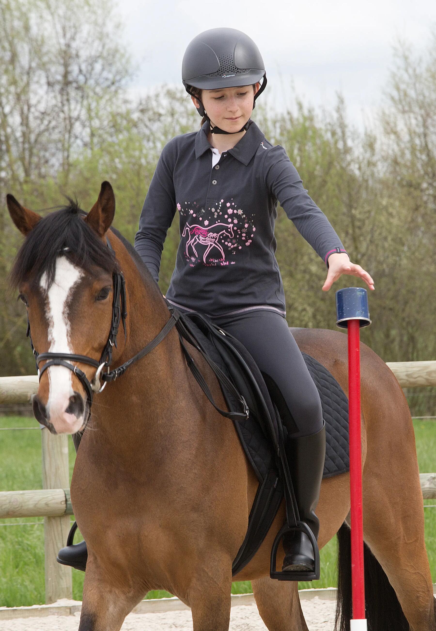 petite fille à cheval qui prend un objet