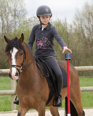 petite fille à cheval qui prend un objet petite fille à cheval qui prend un objet