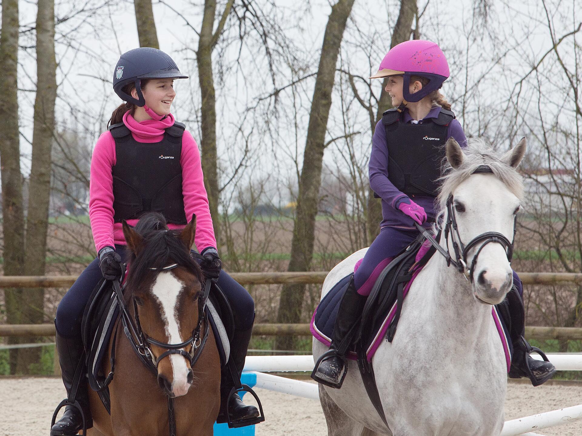 Twee kleine meisjes op hun pony