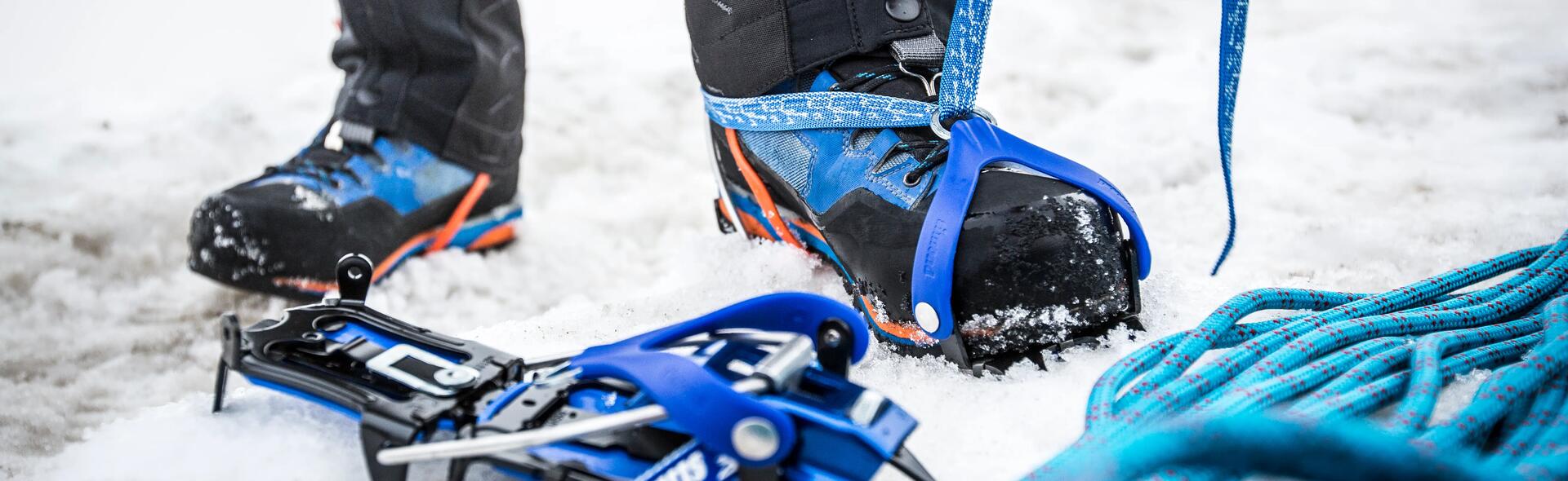 alpinista a calçar crampons