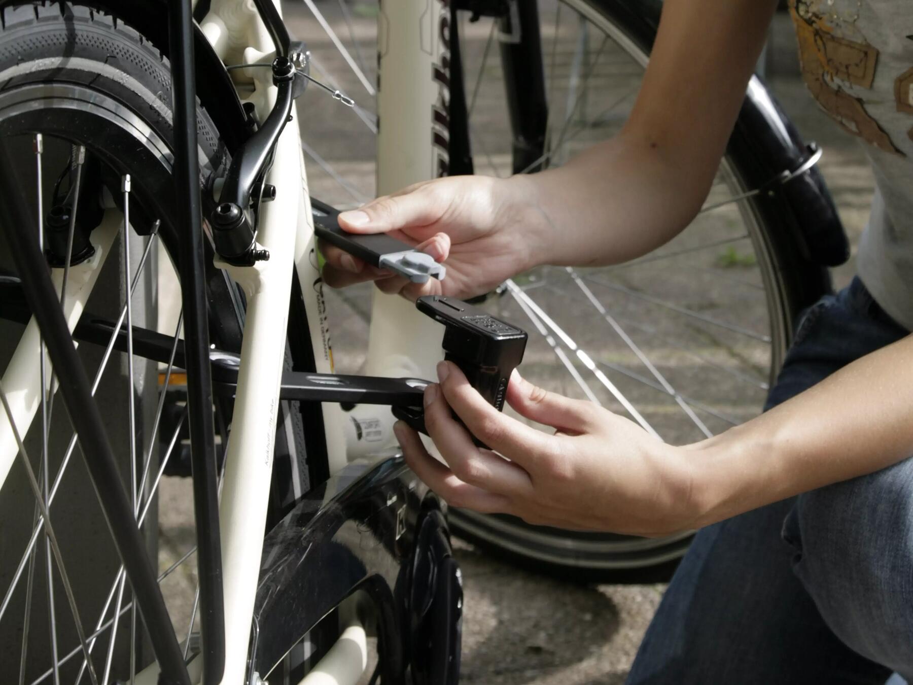 Iemand maakt een fiets vast met een vouwslot