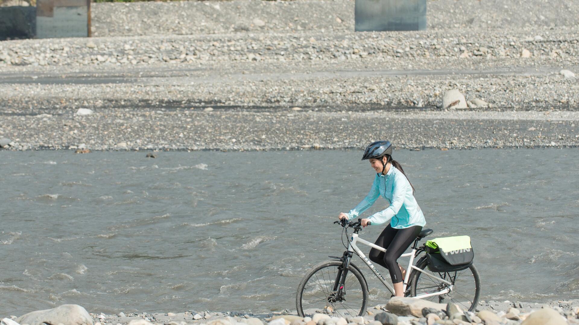 kobieta w kasku rowerowym i odzieży sportowej jadąca na rowerze