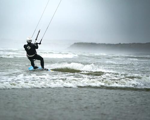 mężczyzna uprawiający kitesurfing w piance kitesurfingowej