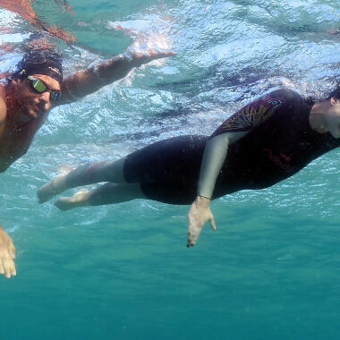 hommes et femme qui font leur fitness au bord de la plage