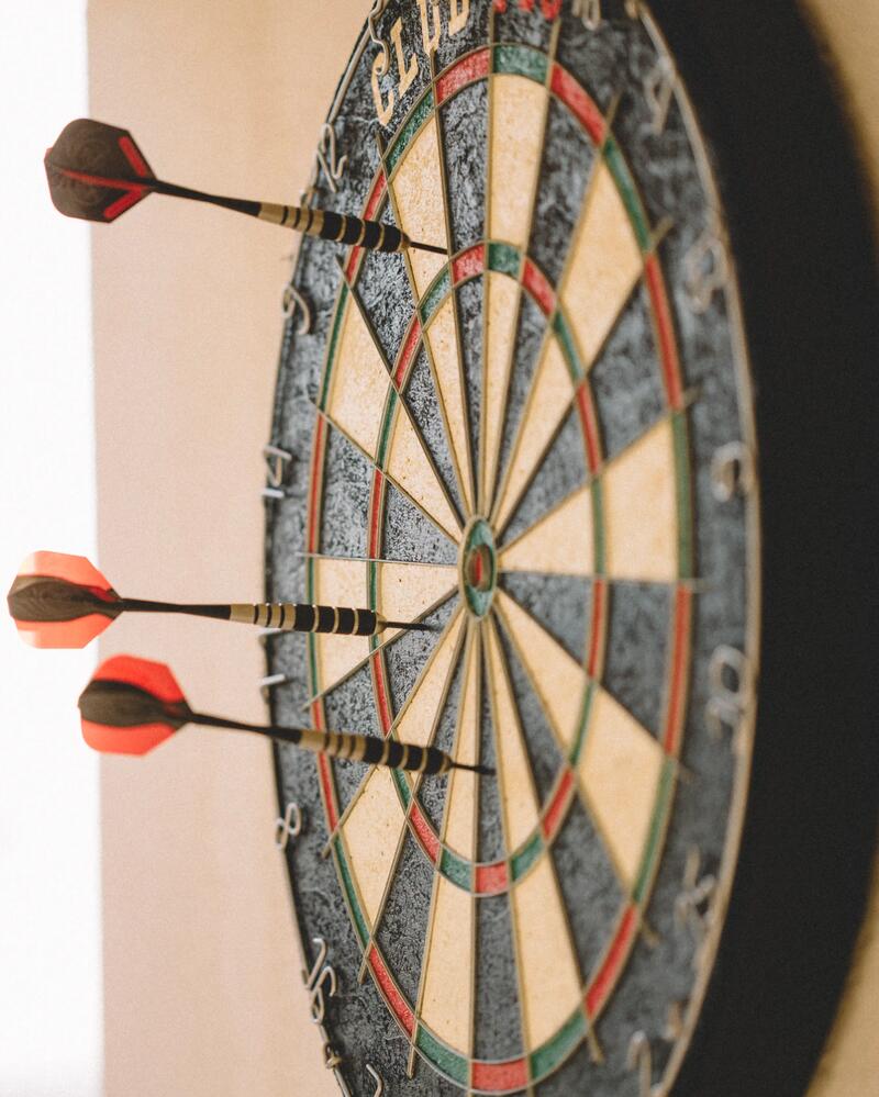 Eine Nahaufnahme einer Steel-Dartscheibe in der 3 Pfeile stecken.