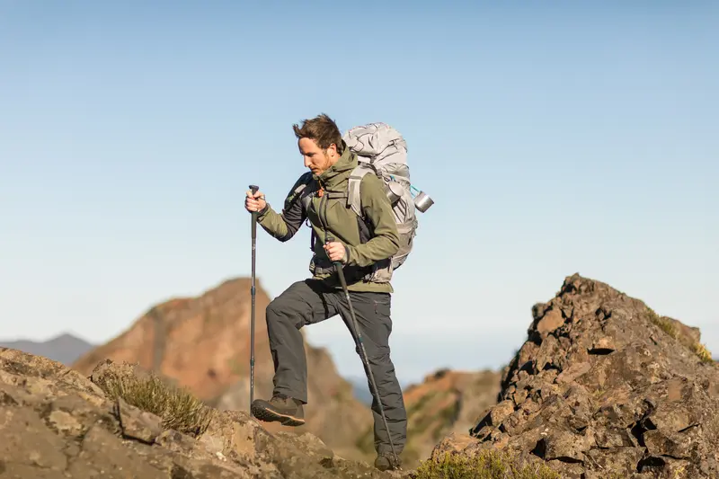 Hombre haciendo trekking con pantalon desmontable