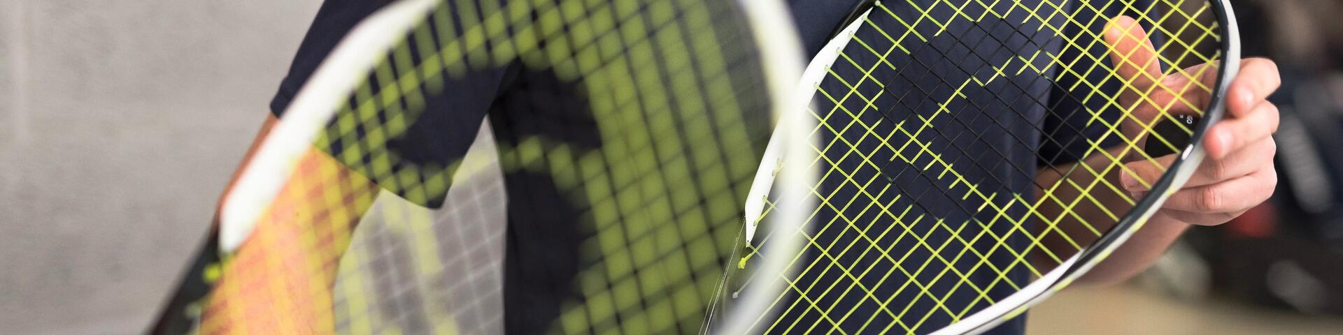 Two people holding two squash rackets