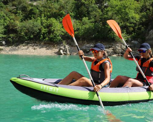 2 girls kayaking on a Green 2 person ITIWIT kayak by the riverbed.