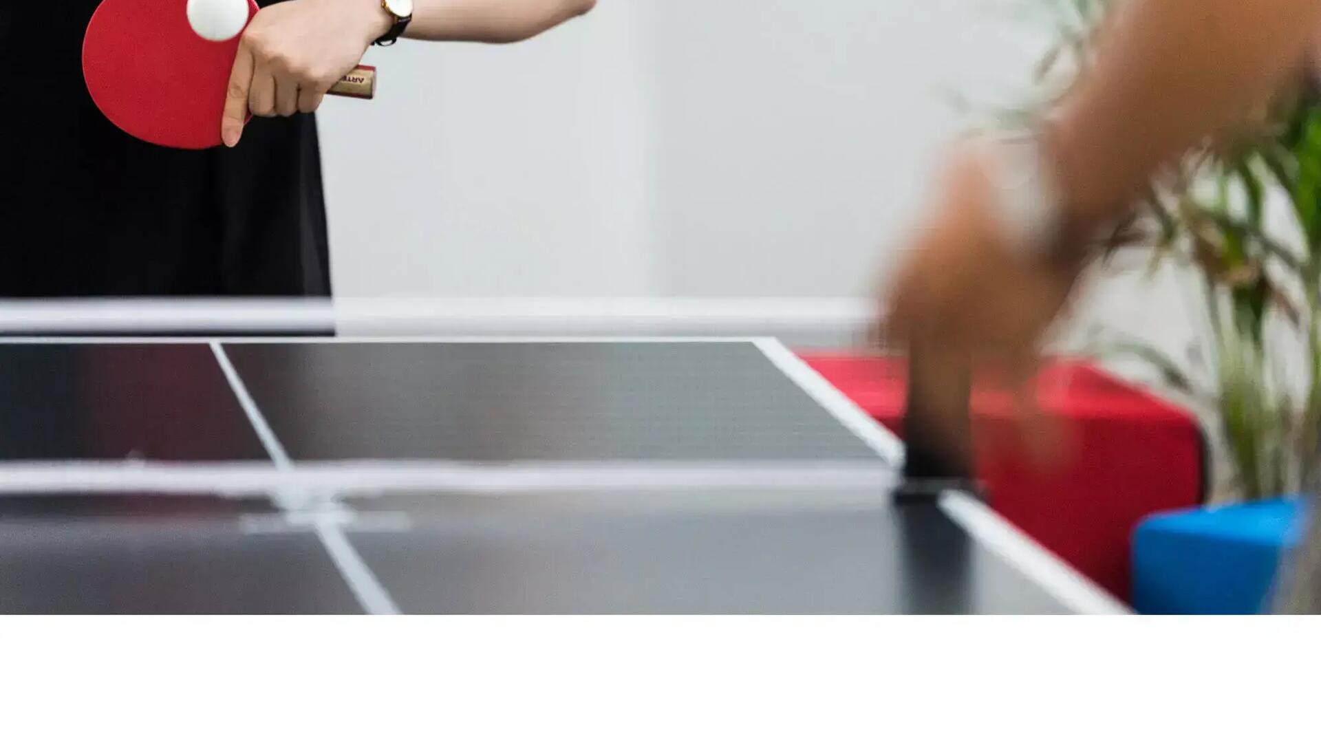 Close-up of two people playing table tennis