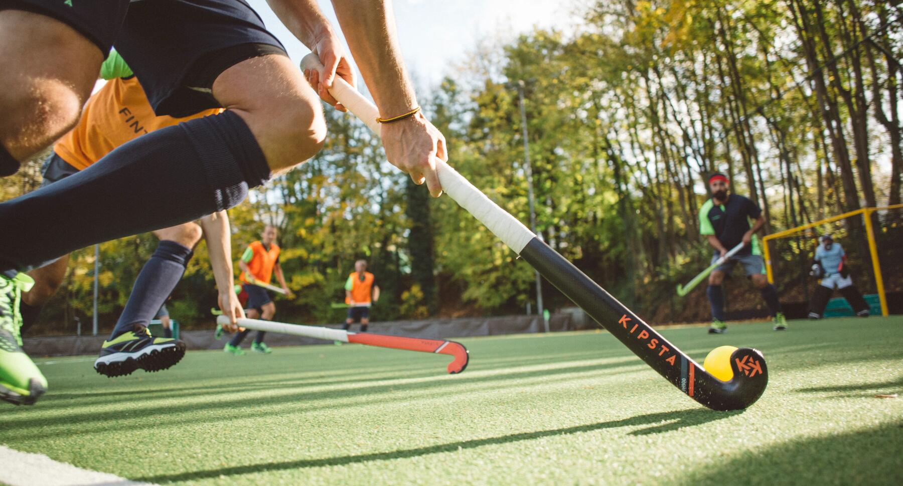 Spieler führt den Spielball mit seinem Feldhockeyschläger