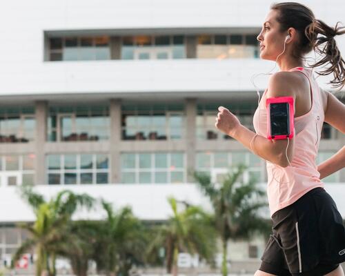 rapariga a correr com telemóvel no braço