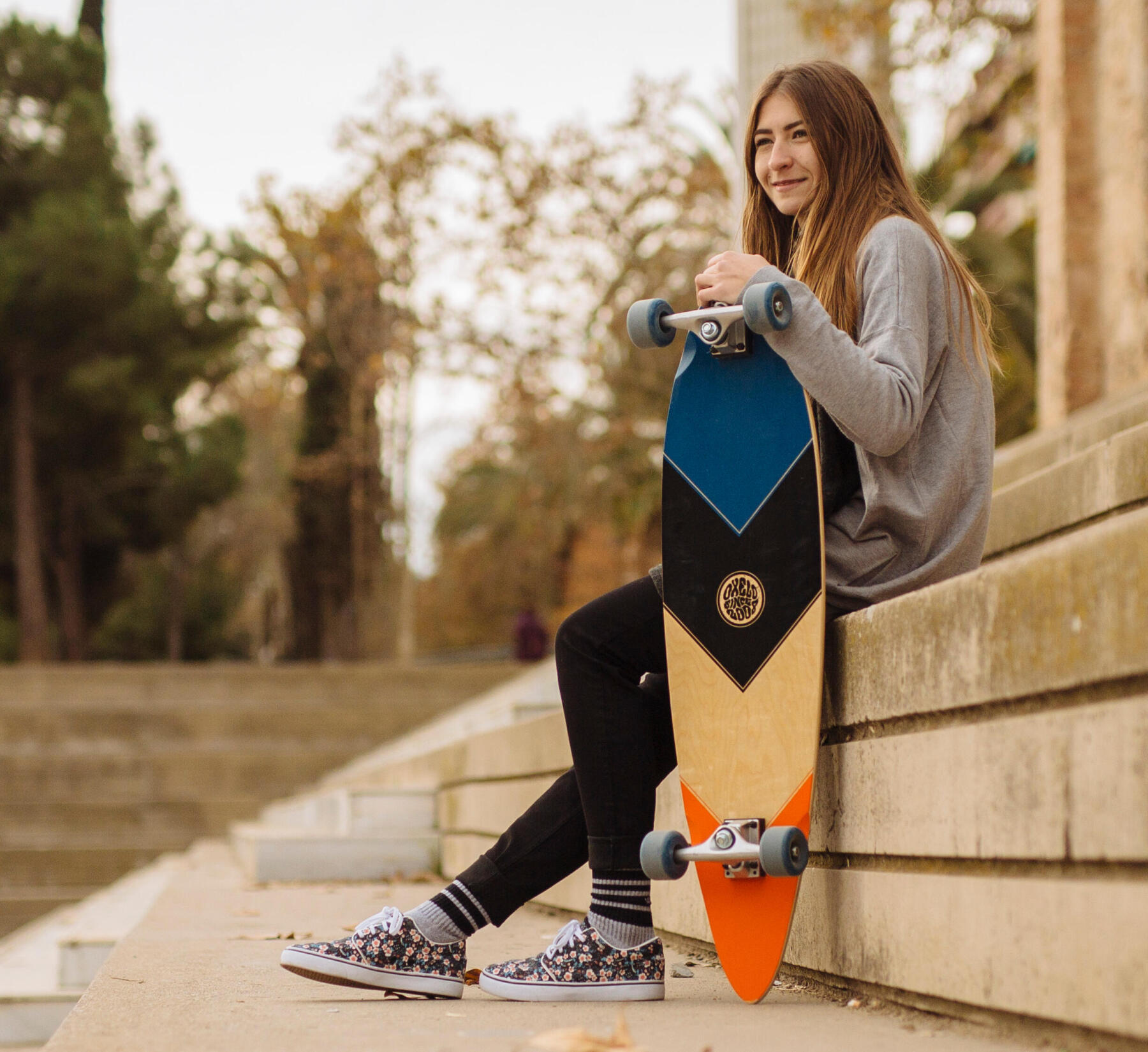 adolescente assise avec sa planche longboard