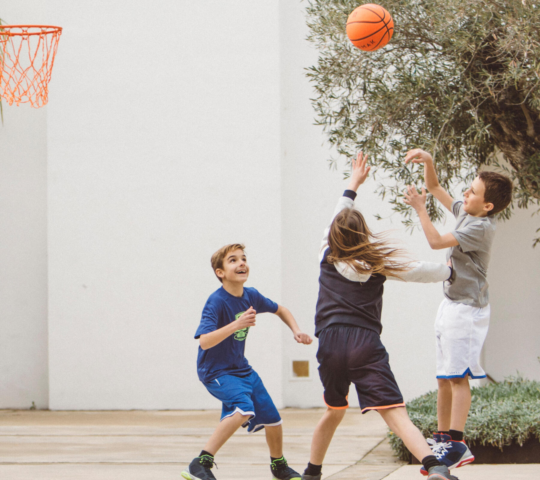 enfants qui jouent au basketball devant la maison