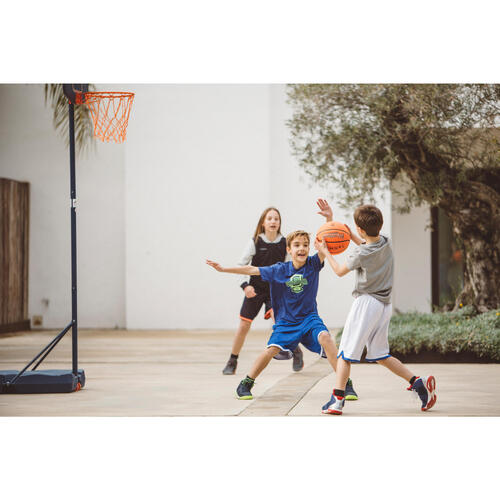 Kids playing basketball in front of the house