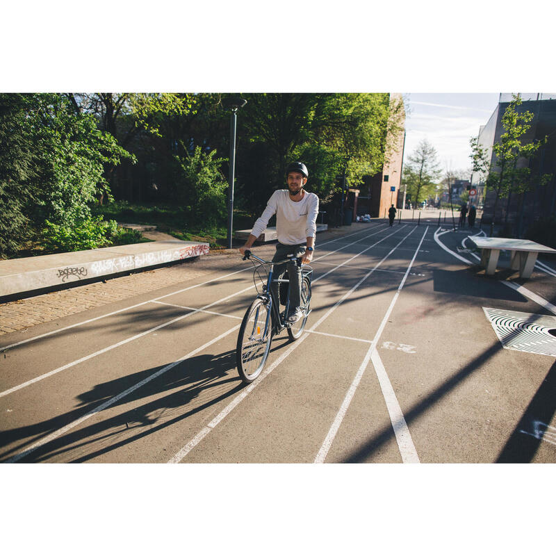 mężczyzna jadący na rowerze miejskim w kasku