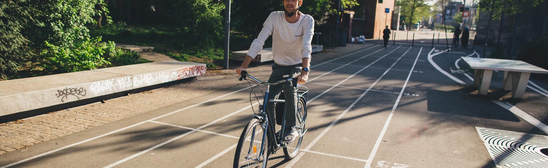 mężczyzna jadący na rowerze miejskim w kasku