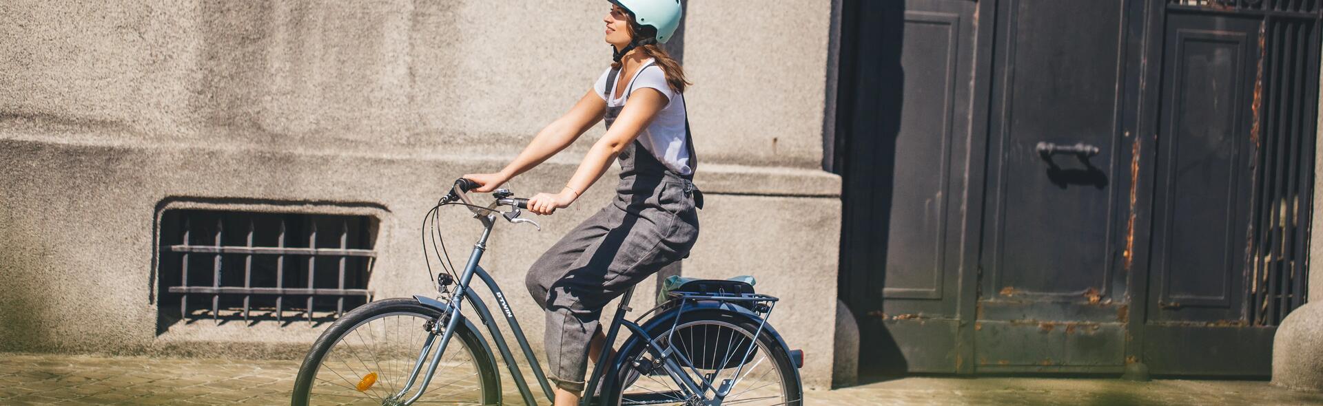 kobieta w kasku jadąca na rowerze elektrycznym miejskim