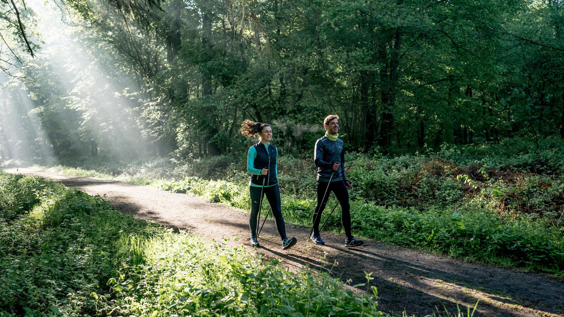 Ein Paar läuft mit Walkingschuhen durch den Wald