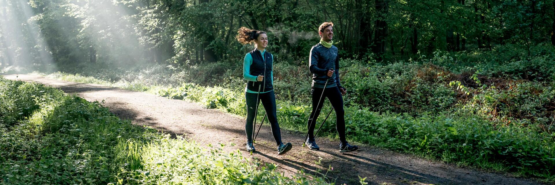 Para uprawiająca nordic walking w lesie