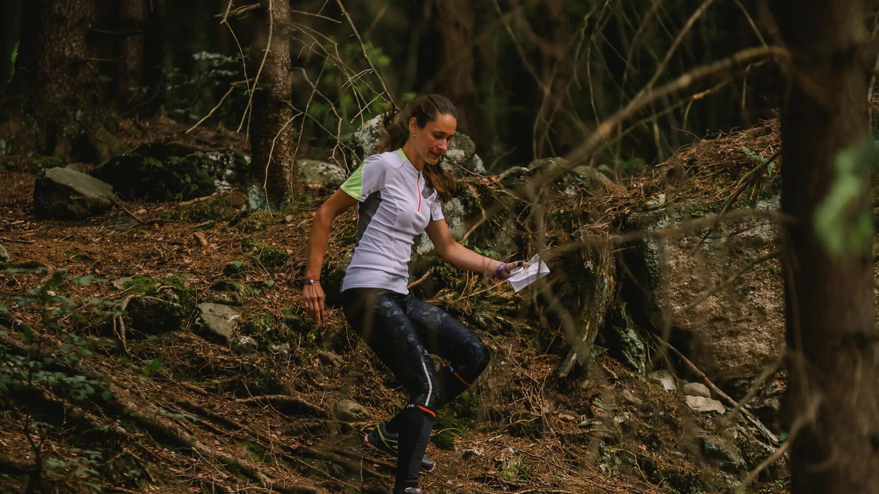Geocaching wird von einer Frau und Kindern im Wald gemacht