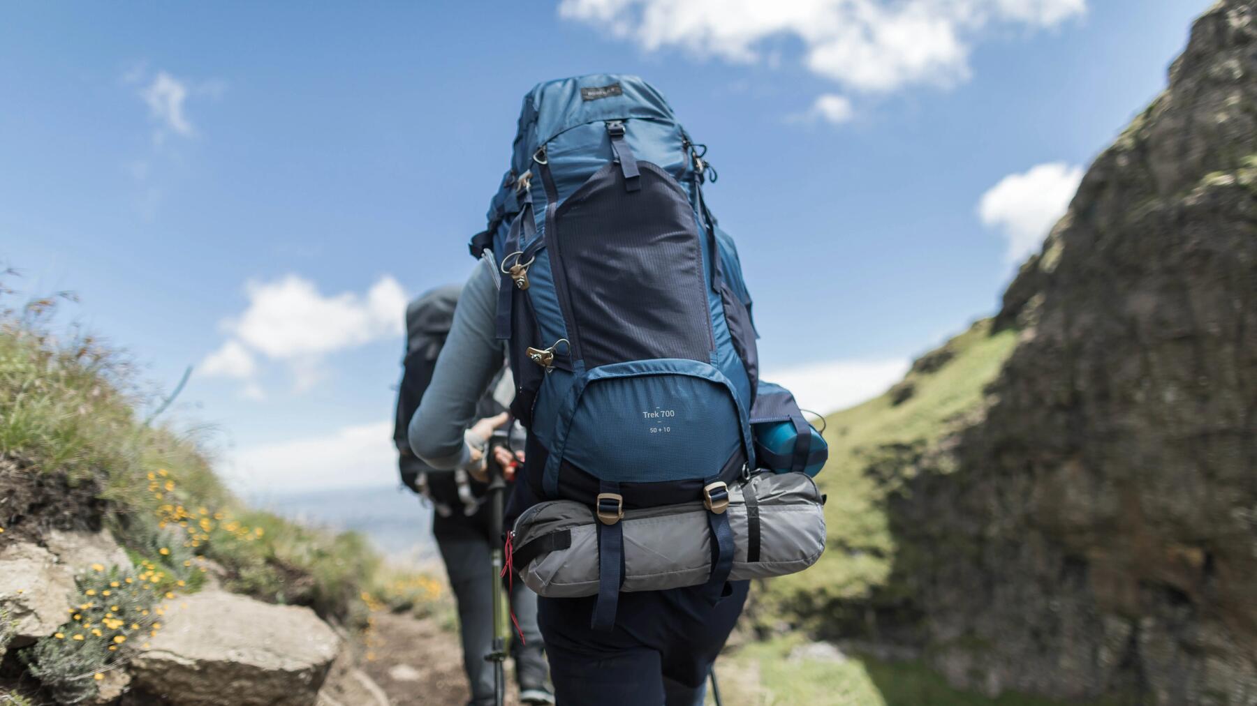 Deux femmes regardent le lever du soleil assises dans leur sac de couchage.