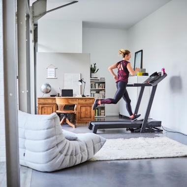 Joggende Frau auf Laufband T900C im Wohnzimmer