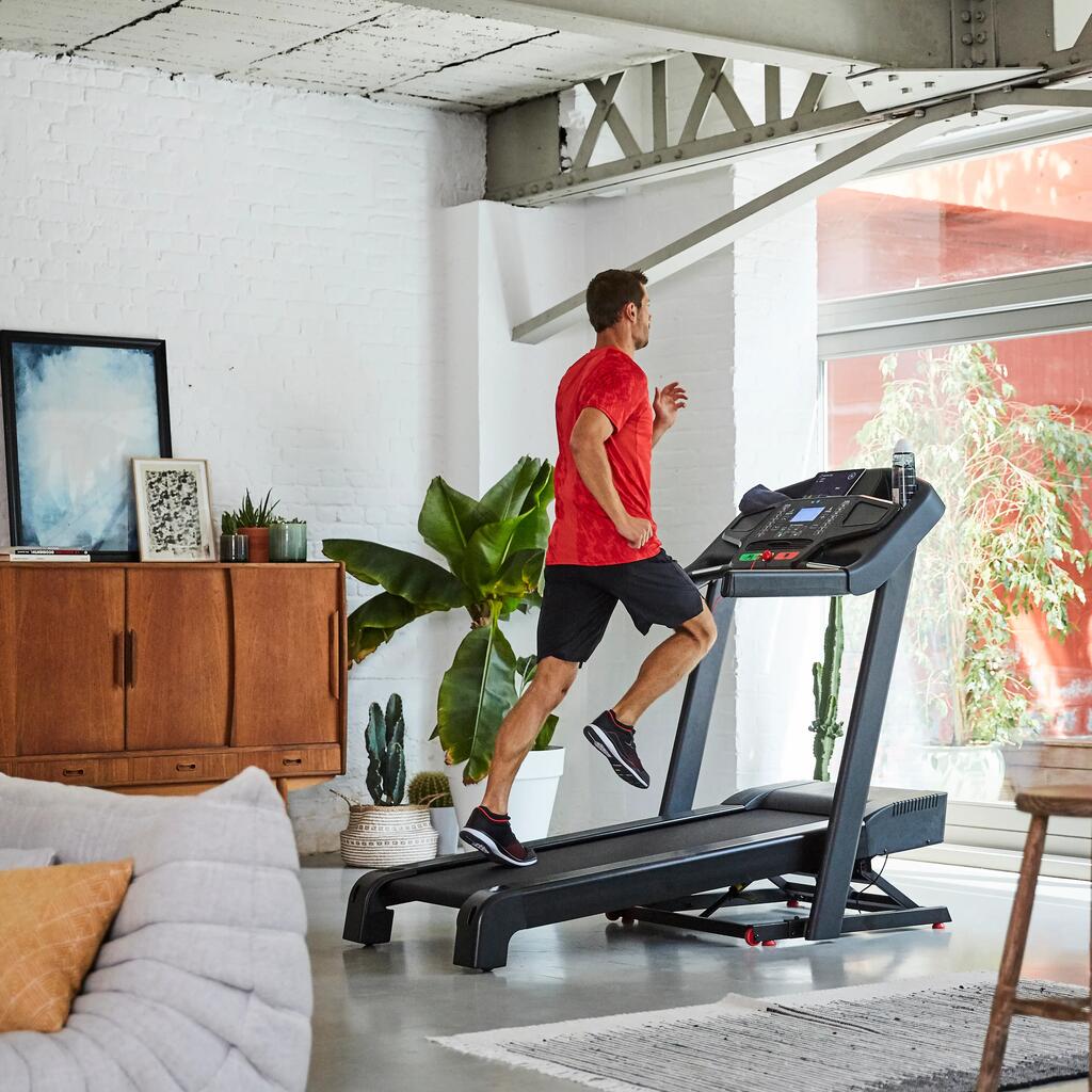 Moški v dnevni sobi teče na Domyos tekalni stezi.