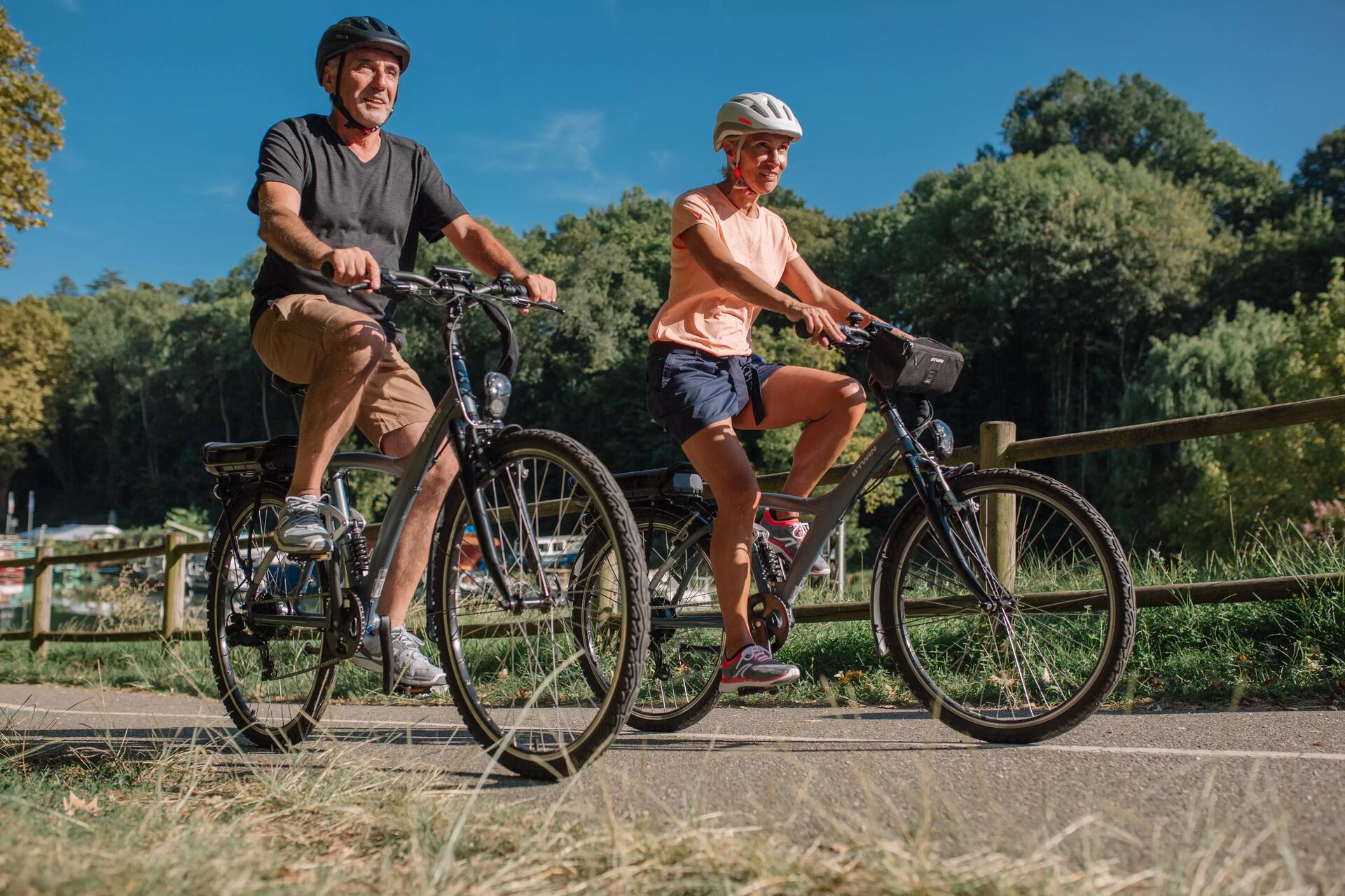 Rowerzyści w kaskach rowerowych jadący na rowerach zastanawiając się jaki rower dla dorosłego wybrać