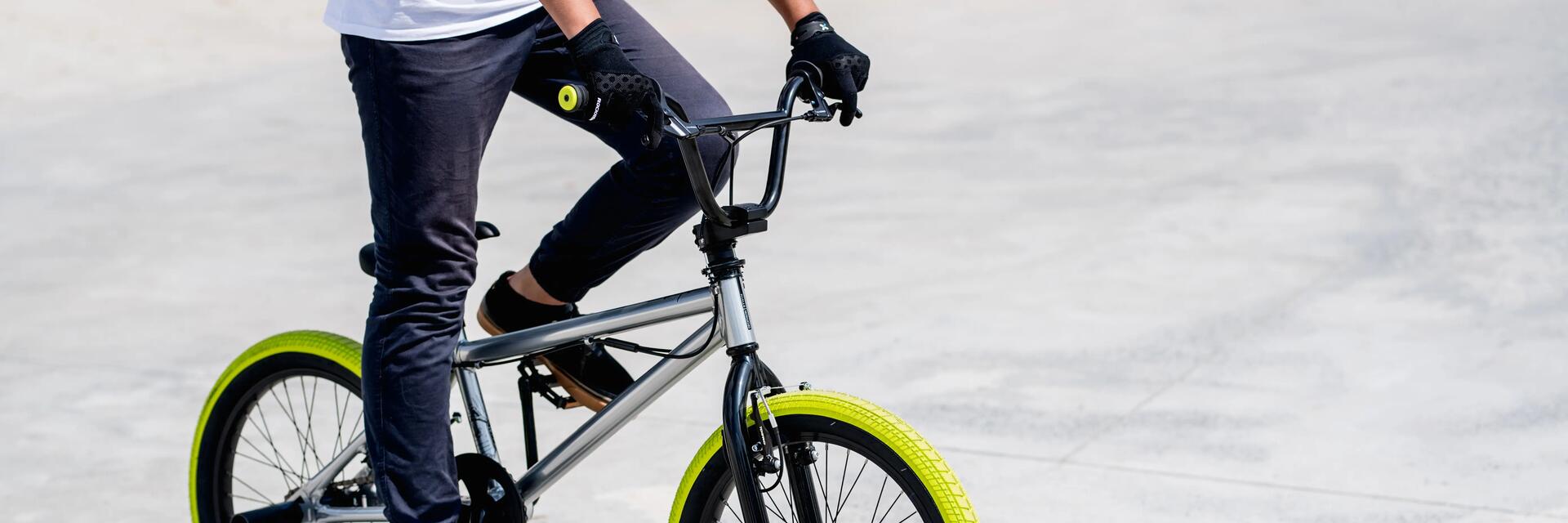Mężczyzna w rękawiczkach jadący rowerem bmx