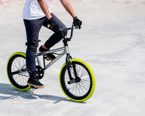 Mężczyzna w rękawiczkach jadący rowerem bmx