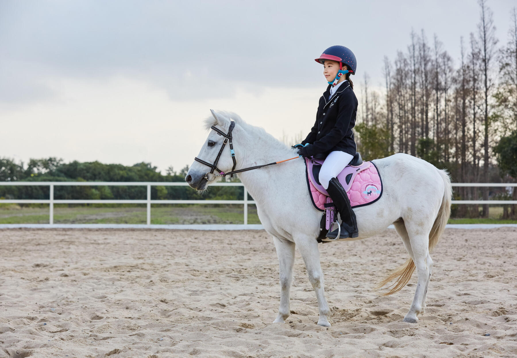 Kind mit Helm auf einem Pferd