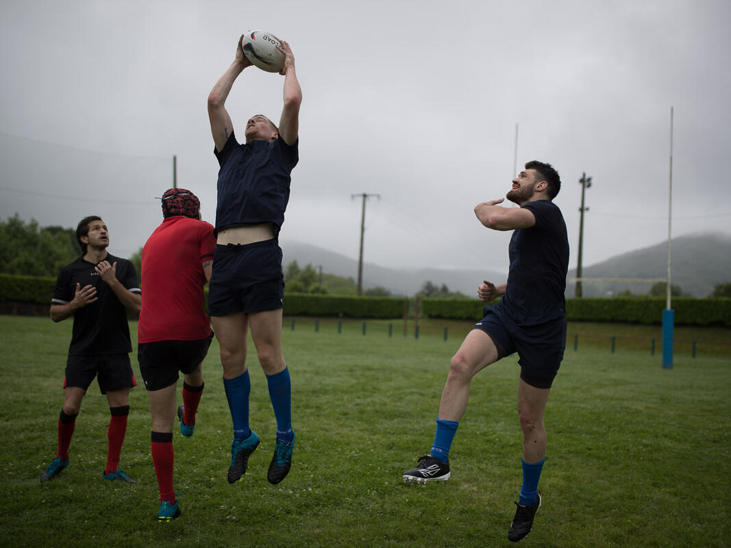 Jogador de rugby que corre com a bola