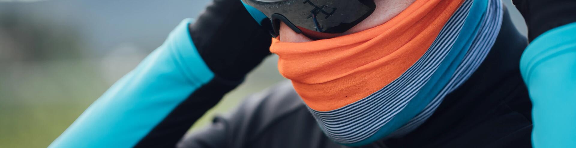 Cyclist adjusting their neck warmer