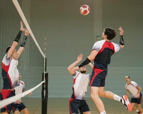 Siatkarze w strojach sportowych grający w siatkówkę