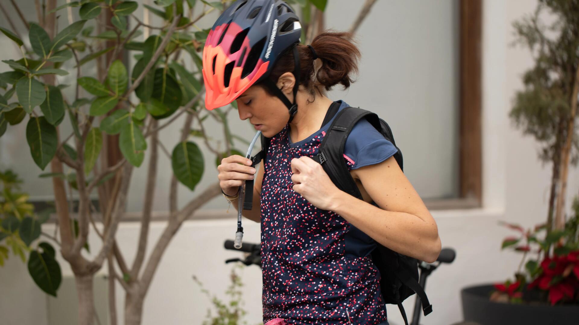 A woman preparing her hydration system before leaving home on her bike