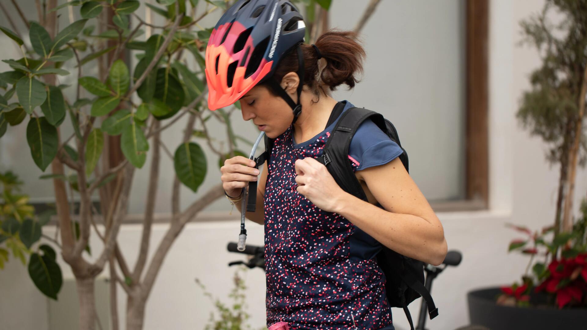 Une femme qui prépare son système d’hydratation avant de quitter la maison à vélo