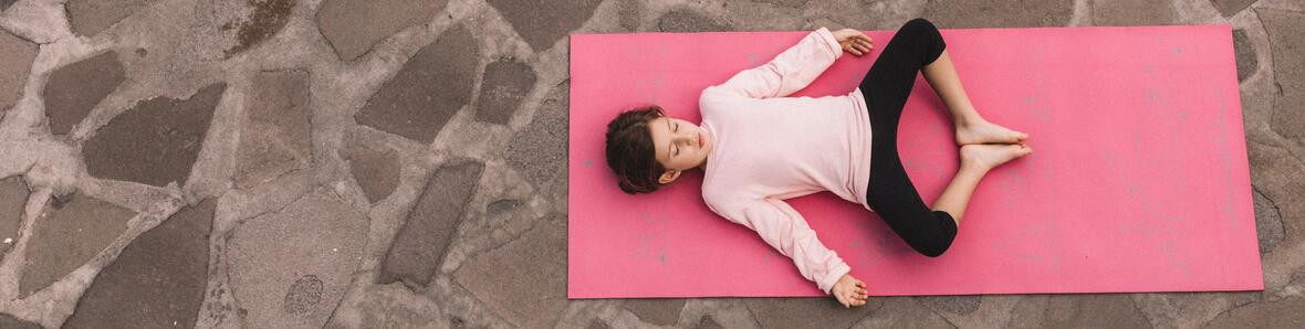 A little girl relaxing and concentrating on a yoga mat