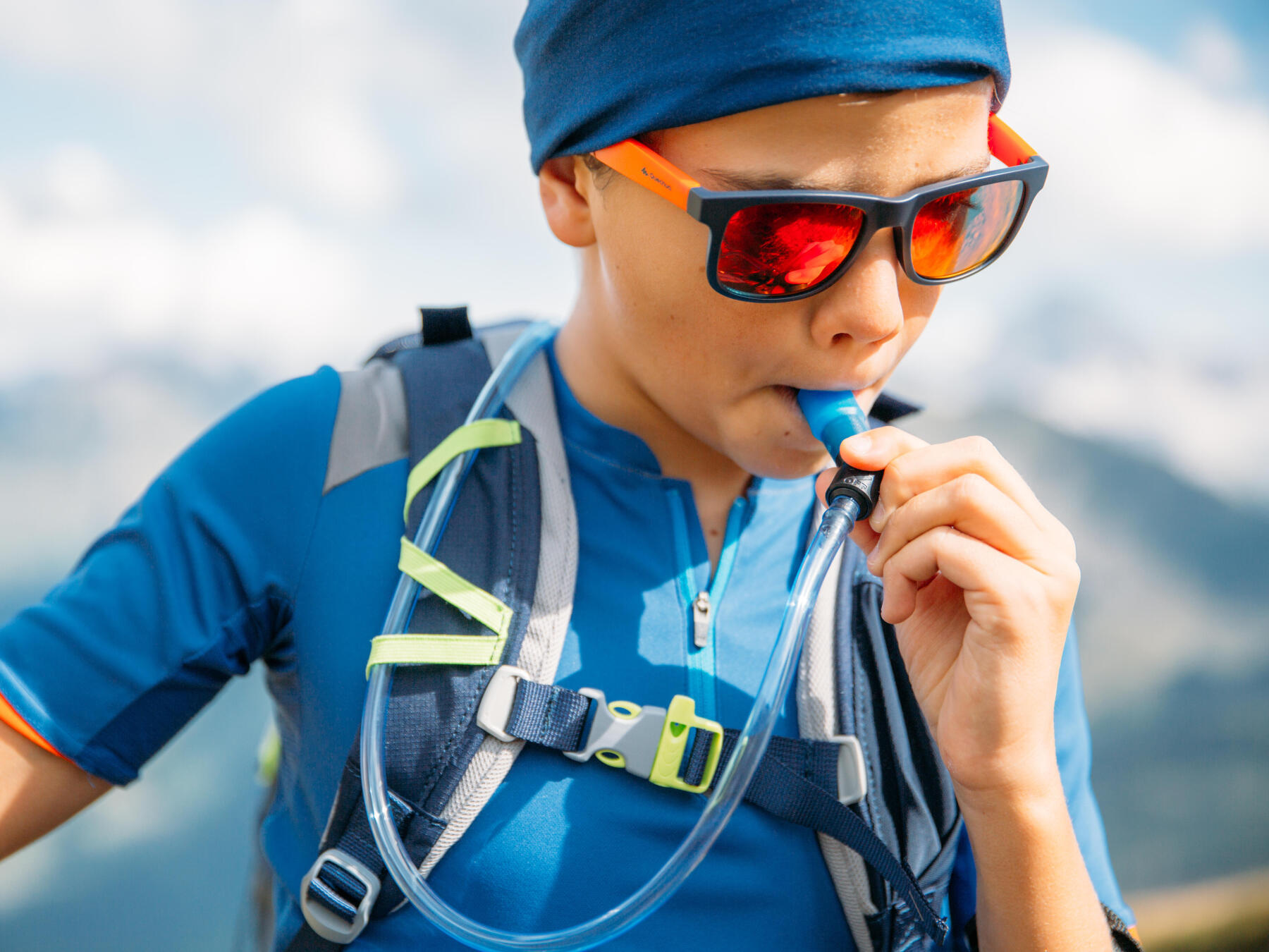 young boy drinking from a hydration pack
