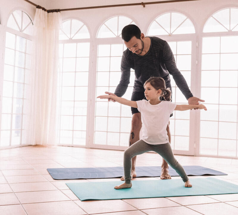 Daddy doing yoga with daughter