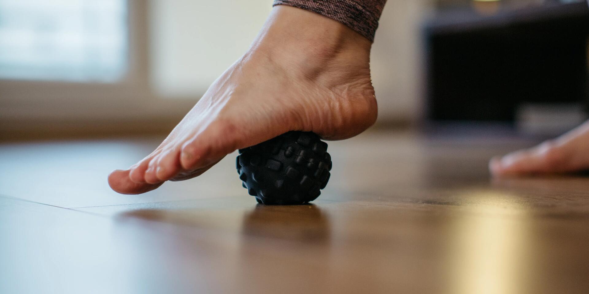 balle de massage sous le pied d'une femme