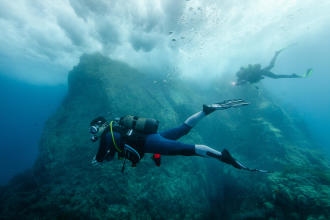 Mergulhador no fundo do oceano com barbatanas de mergulho com Garrafa Volo Race