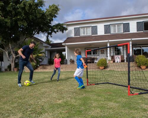 Kids playing with a mobile football goal on the grass